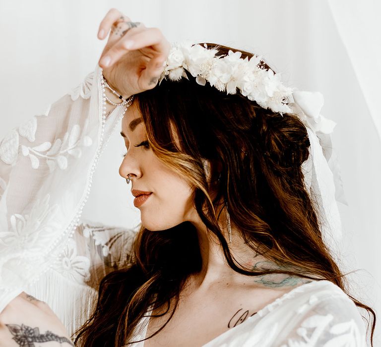 boho bride with white preserved flower crown and bell sleeves