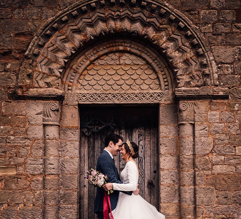 Bride in a ruffled bridal gown kissing the groom in a navy suit at Pauntley Court country house wedding venue 