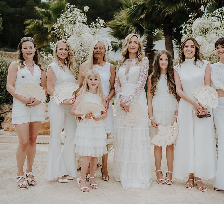 bridal party with mismatched white bridesmaid dresses and outfits and the bride in a long sleeve lace wedding dress