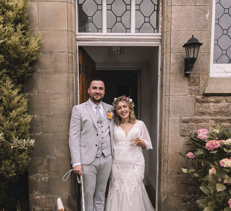 The bride in a quarter sleeve boho gown with groom in light suit with their pet dog 