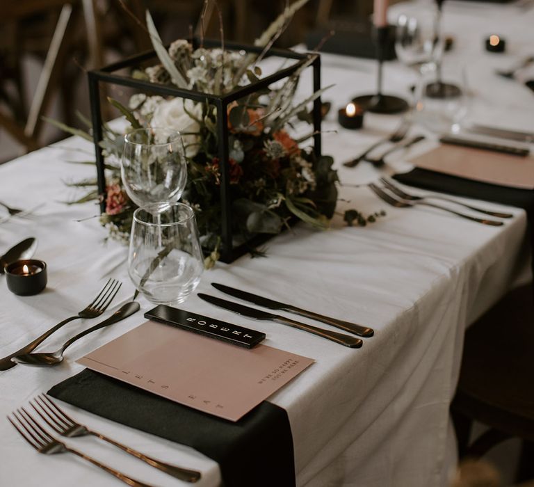 Black and white wedding place name with pink and black wedding place setting decoration and on the day stationery with black square table arrangements