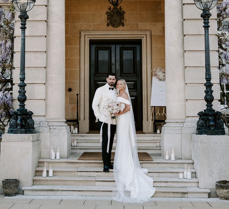 Hedsor House black tie wedding with bride and groom in white wedding outfits 