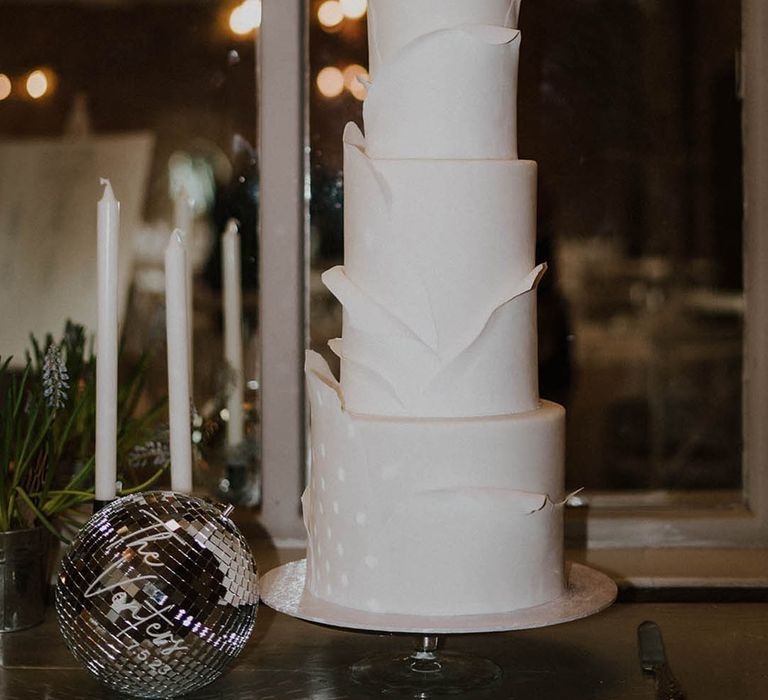 Classic white wedding cake with three tiers with disco ball decorations 