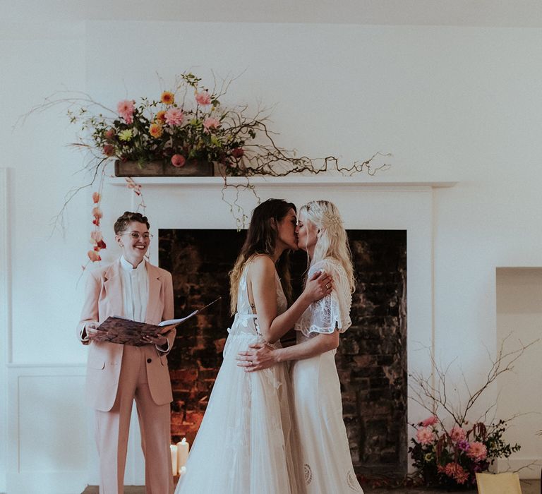 The two brides share their first kiss as a married couple by the celebrant and friend 