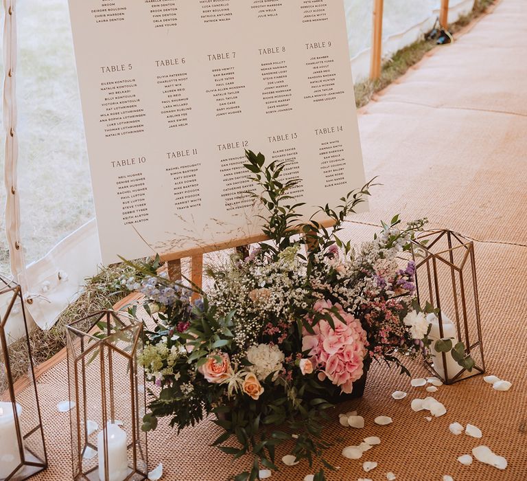 Star theme neutral coloured wedding table seating plan with flowers and lanterns for decor 