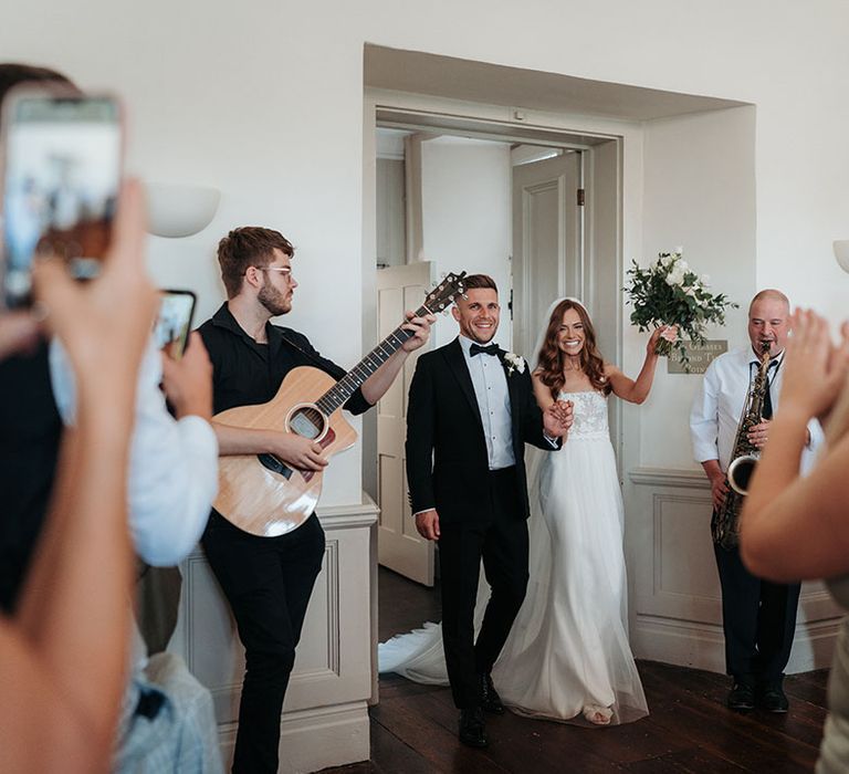 The bride and groom enter the wedding reception 