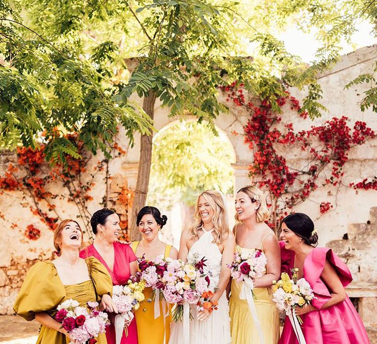 Bride at destination wedding in Italy with bridal party wearing hot pink and yellow bridesmaid dresses 