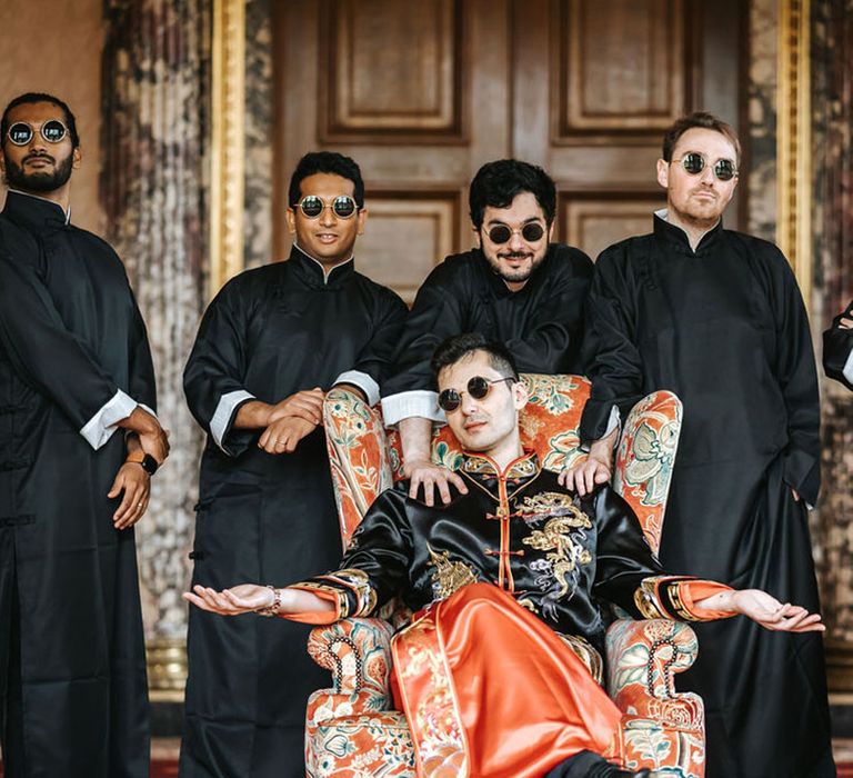 The groom and groomsmen wearing black sunglasses as they pose for group picture together 