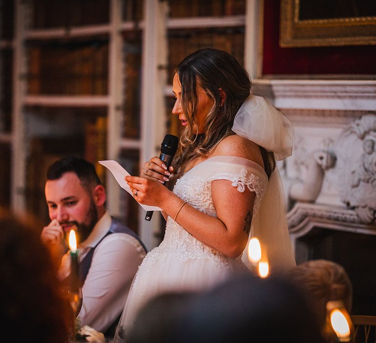 Bride reads out bridal speech at the wedding breakfast in the library at St Giles House  