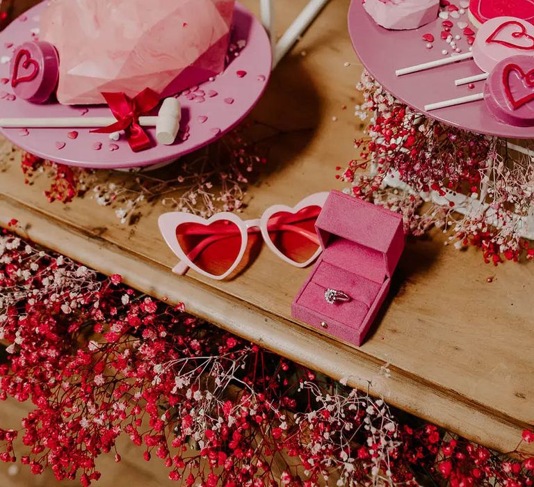 Valentines shoot by Gabrielas Photography and Film with pink and red accessories including sunglasses and lollies 