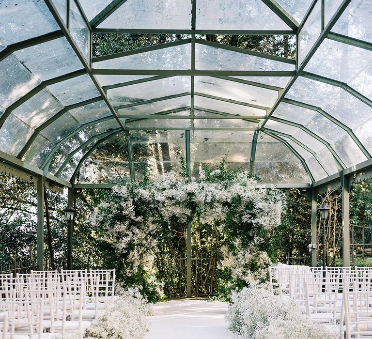 Glasshouse wedding with large gypsophila white wedding flowers made into chuppah for Jewish ceremony 