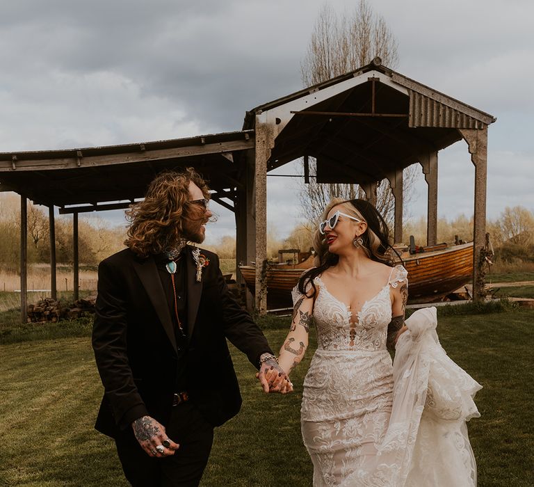 Bride in vintage lace wedding dress walking with groom at Leicestershire wedding 