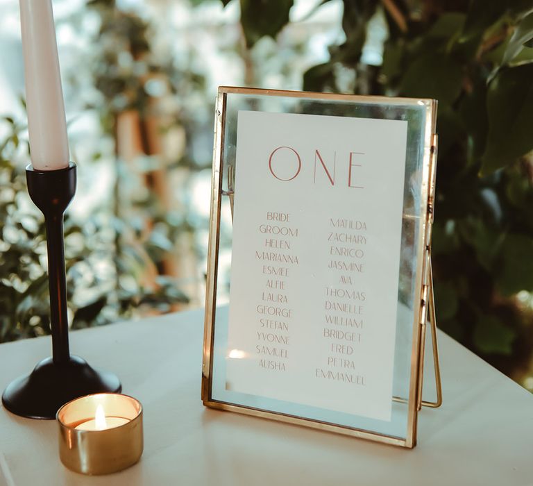 Gold photo frame with table plan made from compostable wedding stationery