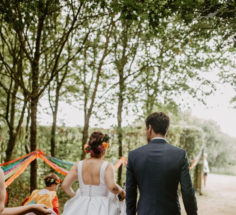 bride and groom walking through the forest 