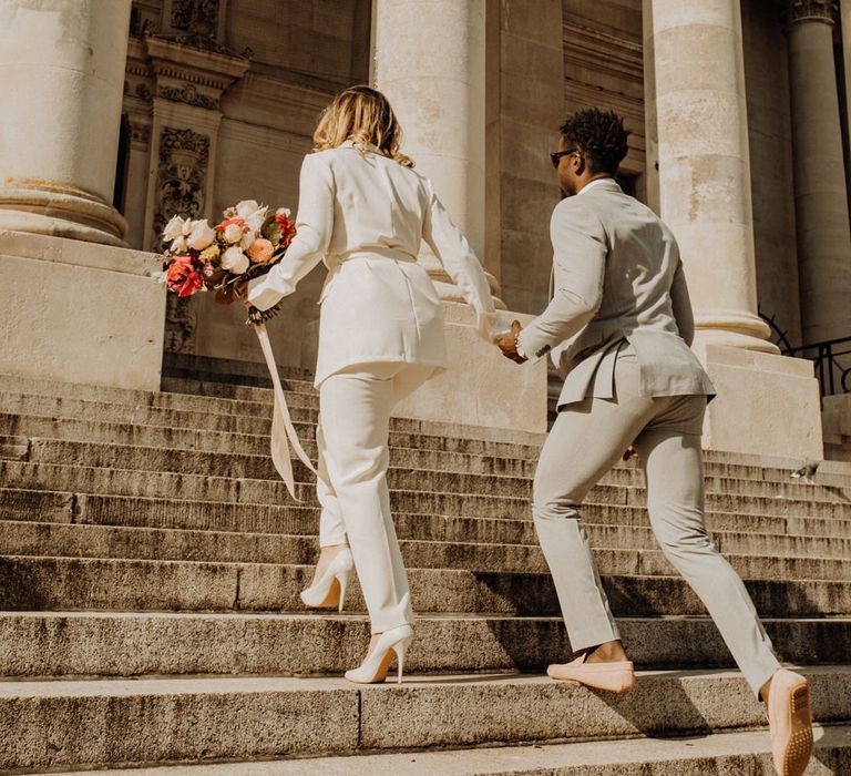 Stylish bride and groom walking up the steps of Portsmouth Guidhall