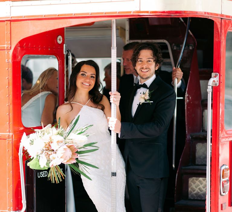 Bride and groom on red London wedding bus