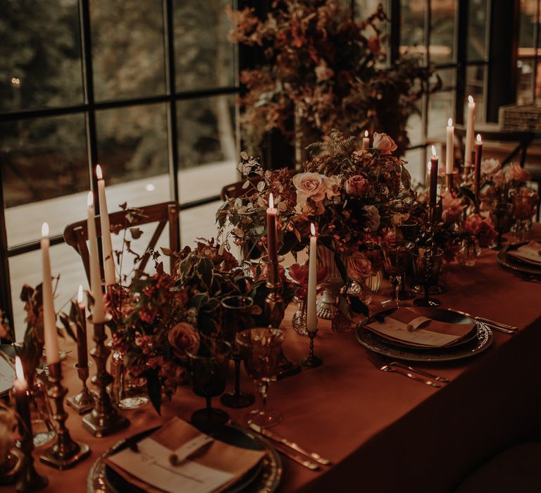 Intimate wedding tablescape with autumn flower centrepieces and taper candles 