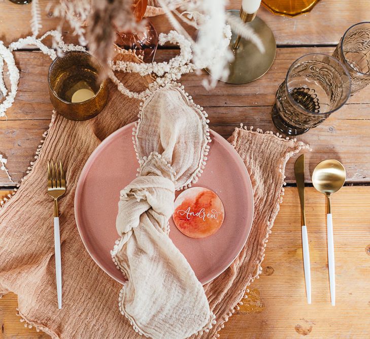 Place setting with pink tableware and natural napkin 