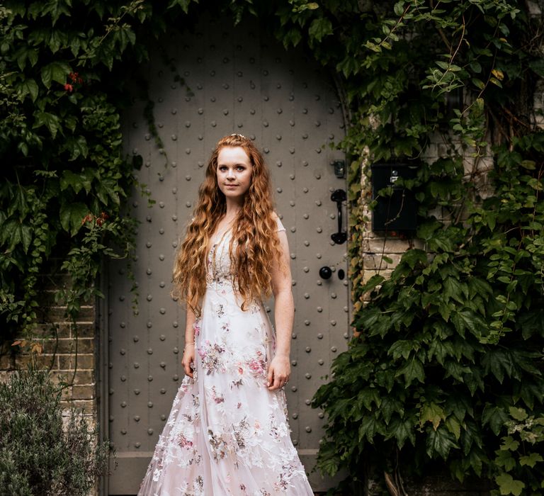 Bride poses in appliqué wedding dress with wavy hair 