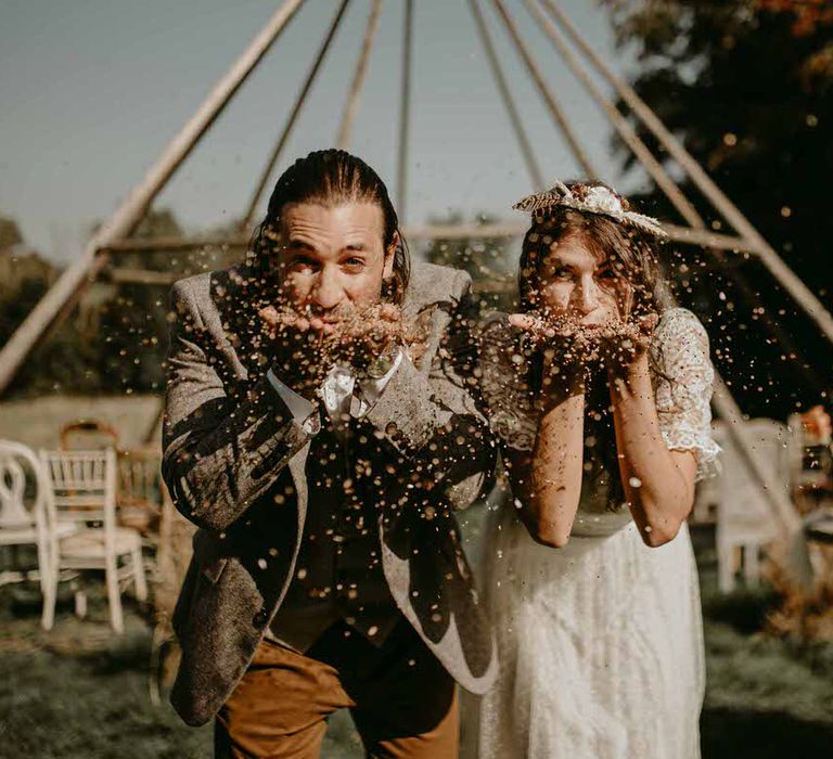 Bride and groom blow natural confetti at sustainable wedding reception