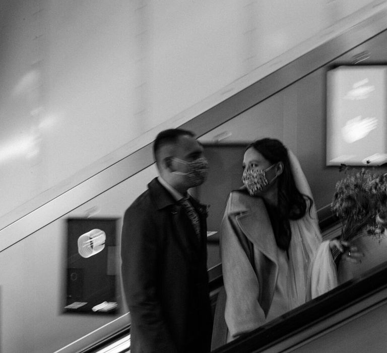 Bride and groom on London escalator for city elopement wedding