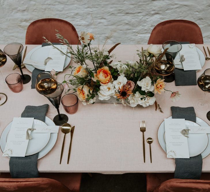 Luxurious and modern wedding tablescape with blush linens, rose gold detailing and velvet chairs