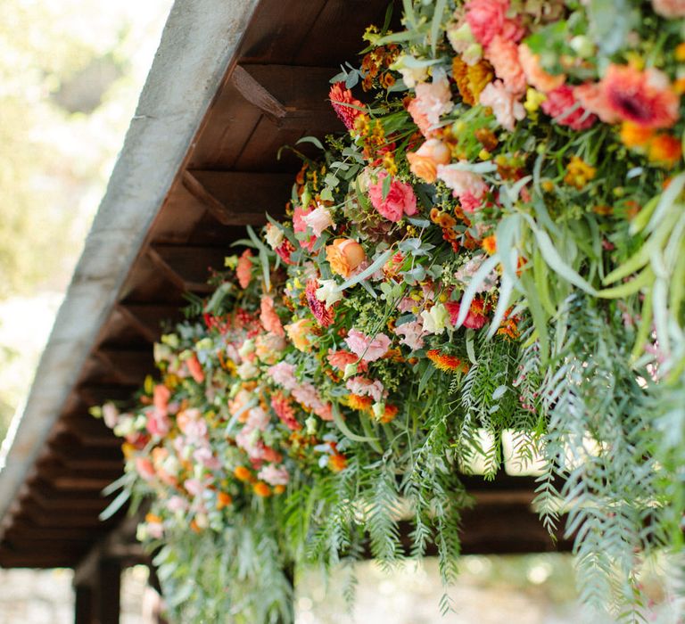 Pink, orange and red hanging flower bouquets for a destination wedding in Greece