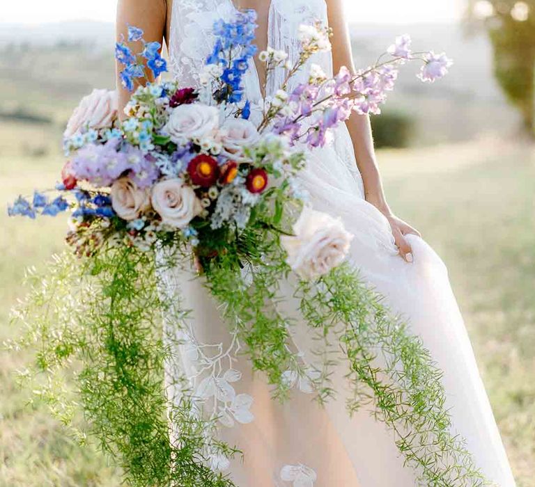 Stunning wedding bouquet with roses, foliage and wildflowers in pastel tones