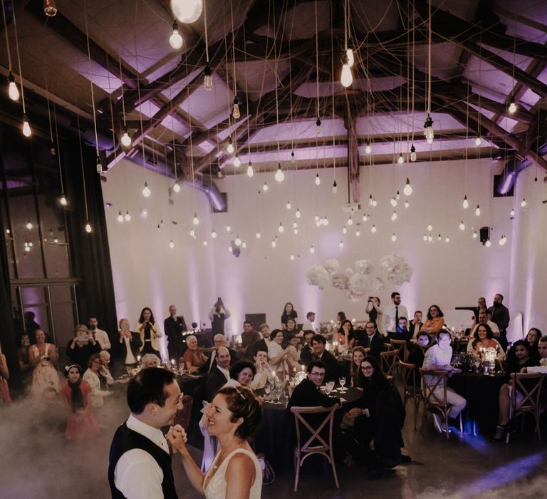 The bride and groom dancing through a floor of magical smoke