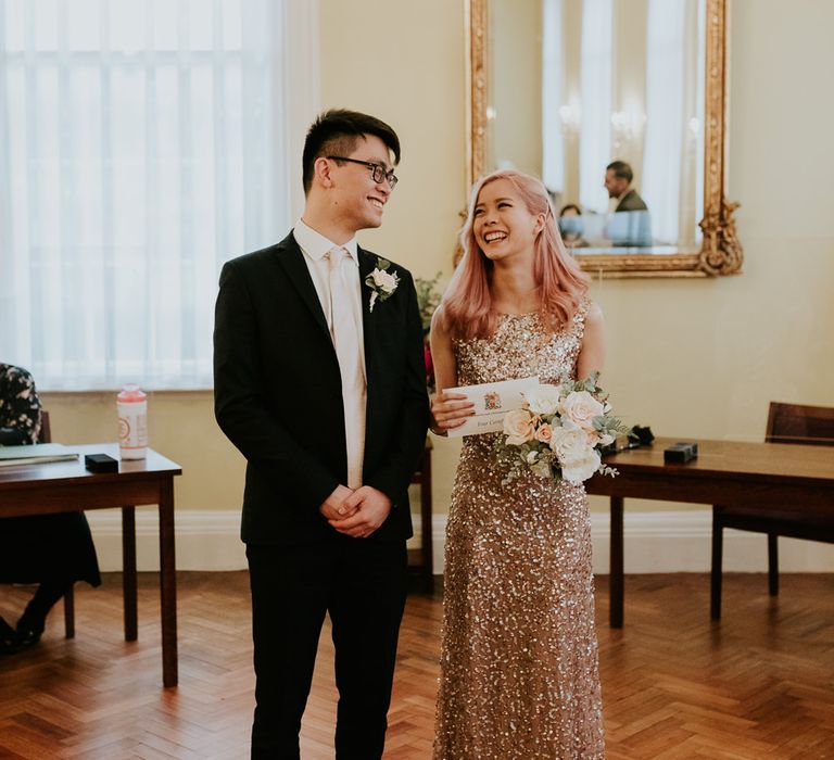 Chinese bride and groom smiling inside Chelsea Town Hall