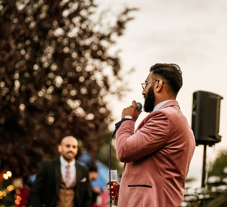 Groom makes a speech at his wedding day wearing pink Topman suit