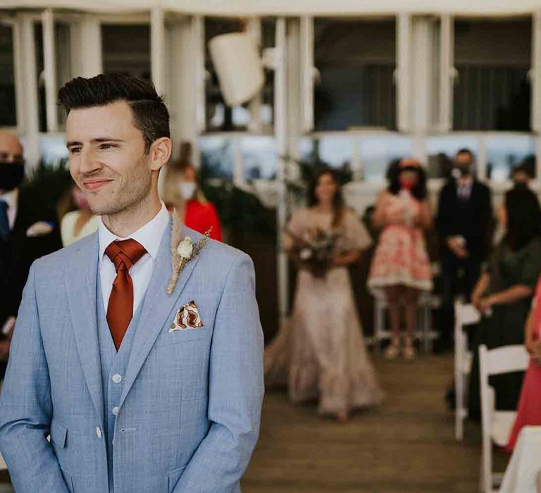 Groom waits for bride walking down the aisle