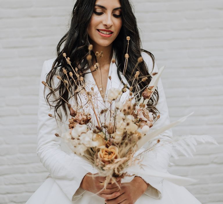 Bride at all white wedding white dried flower bouquet and a tutu blazer wedding dress