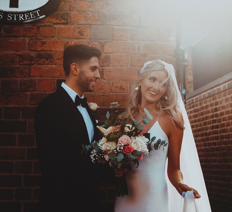 Intimate black tie wedding with groom in a tuxedo and bride in a slip wedding dress