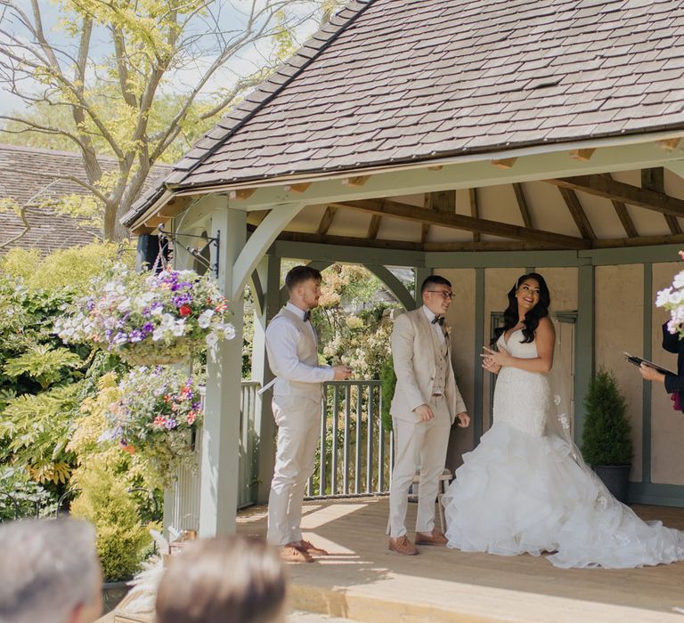 Bride and groom exchanging vows at their outdoor civil ceremony a Cooling Castle Barn wedding venue 