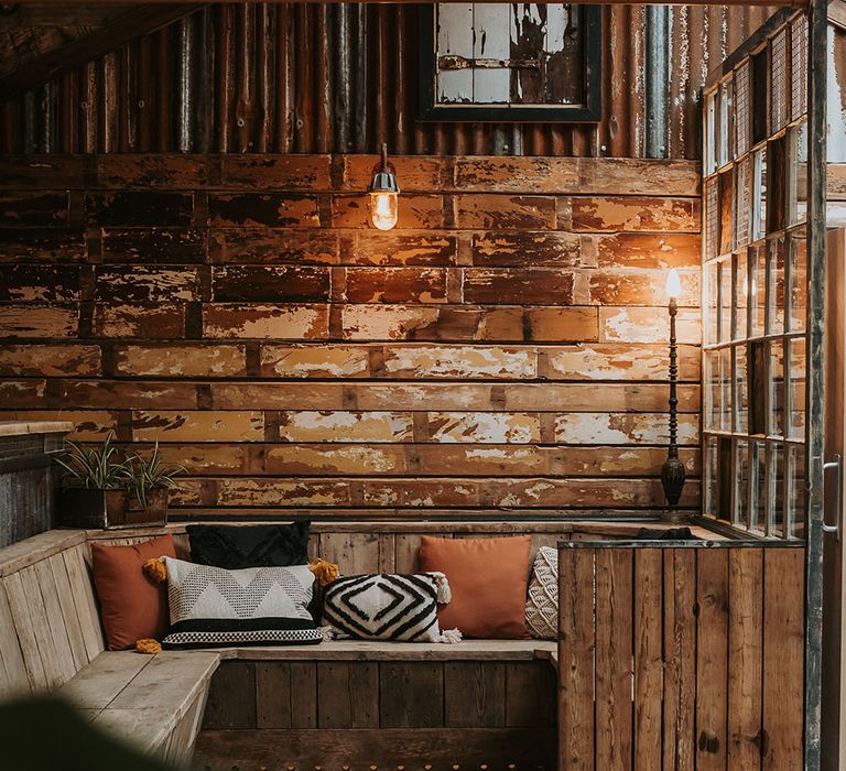 rustic seating area with soft cushions and lighting 