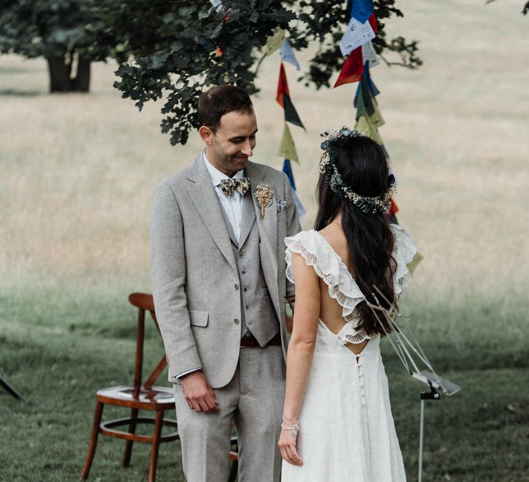 Bride & groom look lovingly at one another on their wedding day as bride wears her dark hair down and in curls