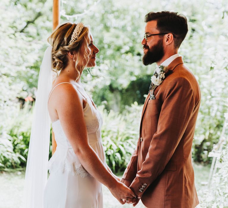 Bride & groom look into one another's eyes on their wedding day during ceremony as they marry and say their vows