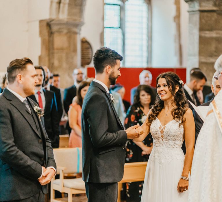 Bride & groom look lovingly at one another as they hold hands on their wedding day