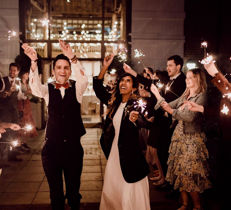 Bride & groom leave during sparkler exit on their wedding day surrounded by guests | Joshua Gooding Photography