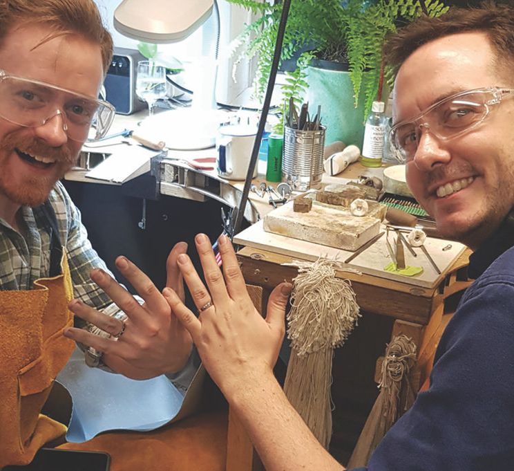 Two grooms show off wedding rings they have made