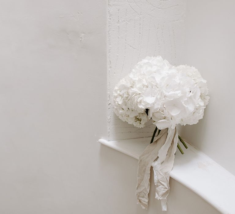 White hydrangea wedding bouquet tied with ribbon 