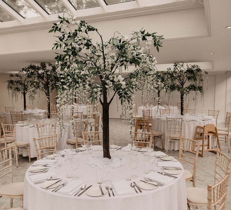 Trees with white flowers as table centre pieces 