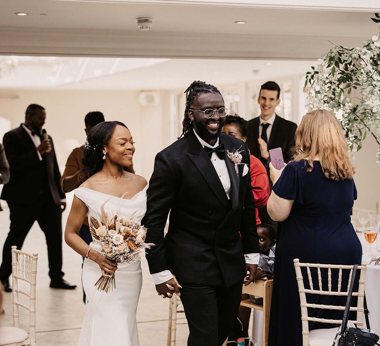 Bride & groom hold hands on their wedding day