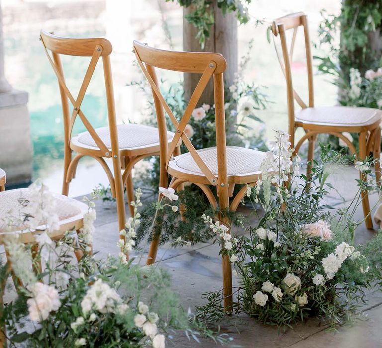 Wooden chairs surrounded by florals on wedding day