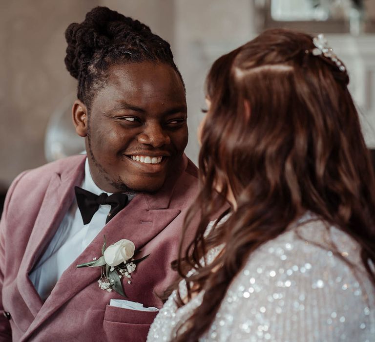 Groom looks lovingly at his bride who wears ASOS wedding gown