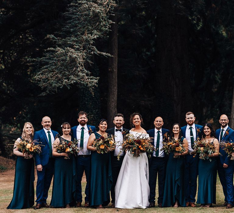 Wedding party all in blue for Askham Hall wedding with bride in off the shoulder dress and groom in matching blue suit