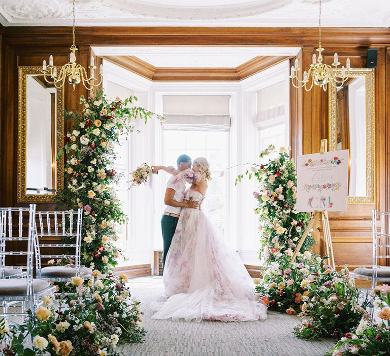 ceremony room at Barnett Hill Hotel with aisle wedding flowers and LGBTQI+ couple kissing at the altar 