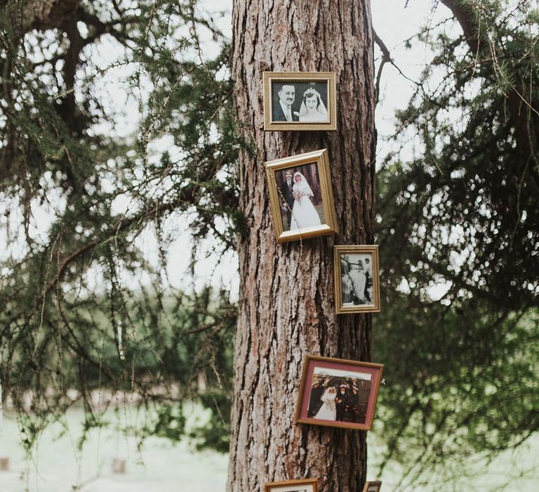 Gold photo frames with family photos of the couples' parents and grandparents wedding 