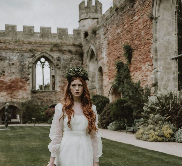 Sustainable bride in a two layer wedding dress and flower crown holding a foliage bridal bouquet in the gardens at Bishop's Palace Wells